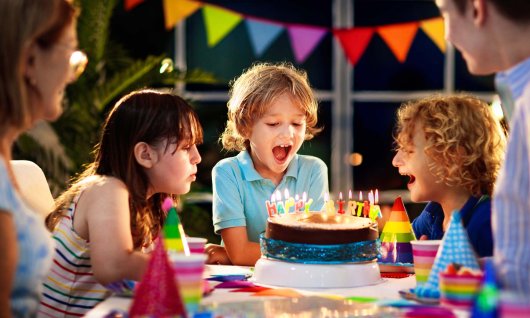 Kinder sitzen mit Kuchen am Tisch