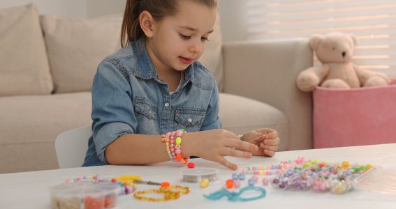 Mädchen bastelt Armbänder