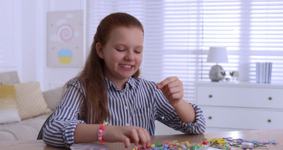 Mädchen bastelt Armbänder