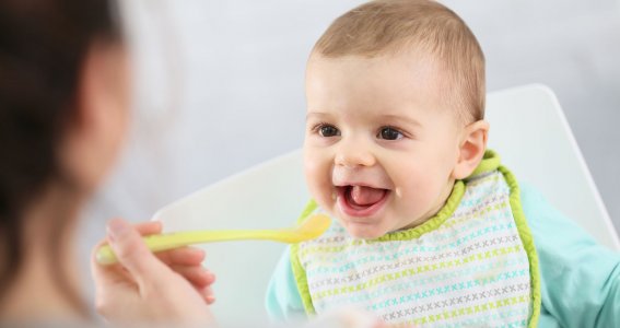 Mutter gibt Baby den Löffel