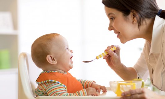 Mutter gibt Baby den Löffel