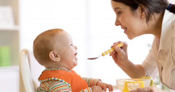 Mutter gibt Baby den Löffel