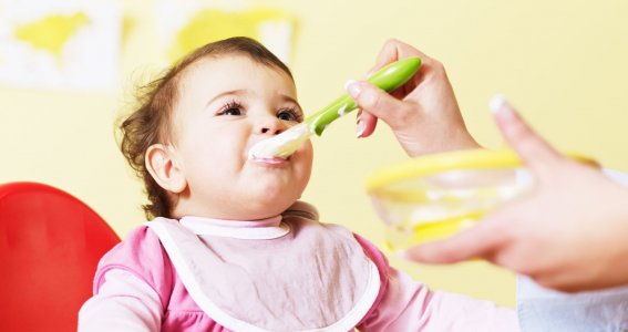 Mutter gibt Baby den Löffel 