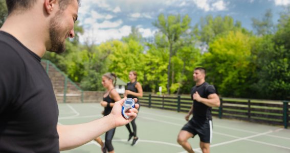 Mann misst Zeit von einer Sportgruppe