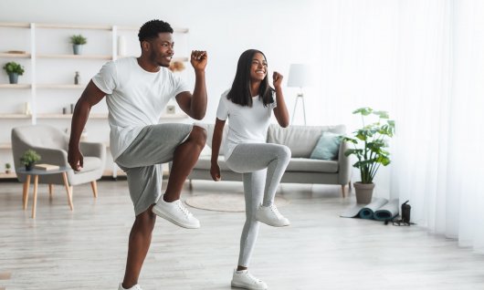 Ein junges Paar macht eine Übung und hält den Ellbogen zum Knie