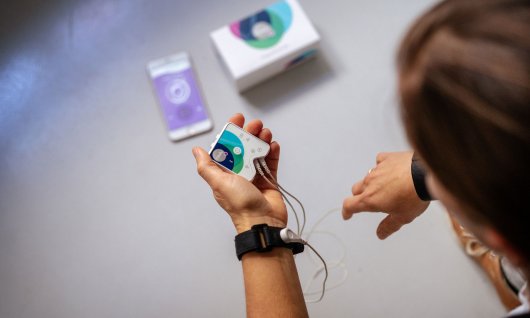 Eine Frau hält ein Healy Gerät in den Händen