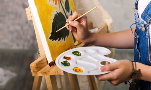 Frau malt auf eine Leinwand