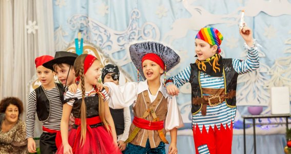 Kinder führen ein Theaterstück als Piraten auf. 