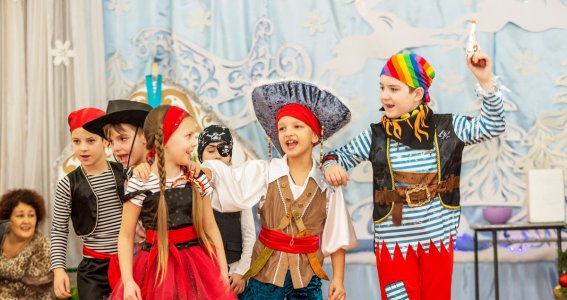 Kinder führen ein Theaterstück als Piraten auf. 