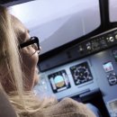 Frau sitzt im Cockpit eines Flugsimulators