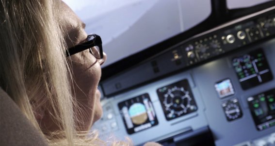 Frau sitzt im Cockpit eines Flugsimulators