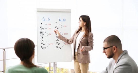 Lehrerin erklärt Englisch an einem Whiteboard. 