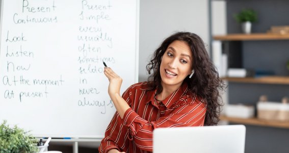 Frau unterrichtet vor Laptop Englisch online. 