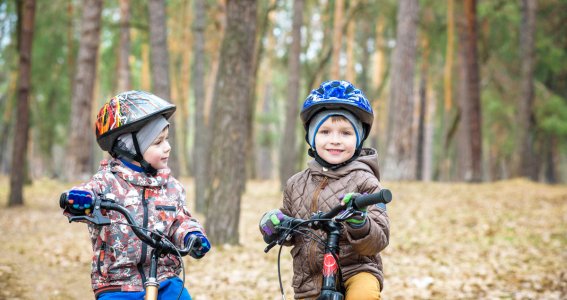 Zwei Kinder sitzen auf ihren Fahrrädern im Wald