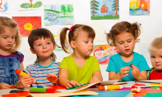 Englischsprachkurse für Kinder in Düsseldorf Kinder sitzen am Tisch und malen.