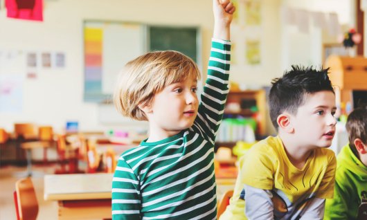 Englischsprachkurse für Kinder in Düsseldorf Kind hebt die Hand.