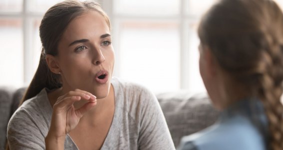 Frau bringt einem Mädchen die Aussprache bei