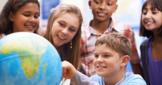 Kinder schauen auf einen Globus