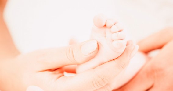 Mutter massiert die Füße ihres Babys