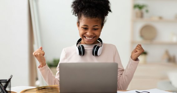 Mädchen sitzt am Laptop