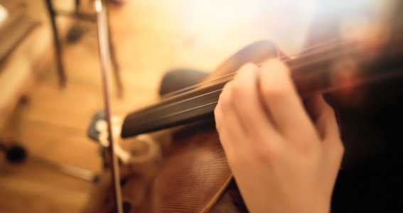 Eine Frau spielt fokussiert Cello