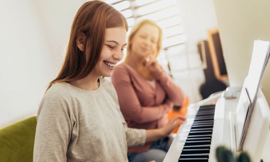 Mädchen lacht am Keyboard