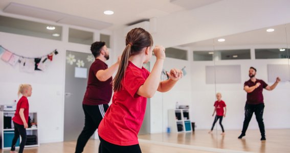 Trainer übt mit den Kinder eine Jazz Choreographie