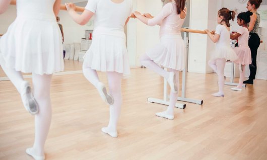 Balletttänzerinnen machen Übungen an der Ballettstange