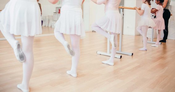 Balletttänzerinnen machen Übungen an der Ballettstange