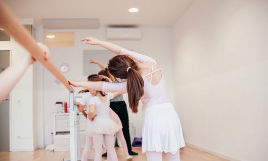 Tänzerinnen machen Übungen an der Ballettstange