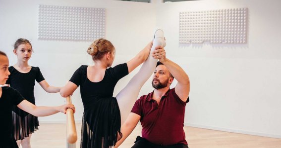 Tanzlehrer hilft bei einer Übung