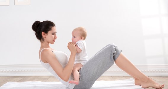 Frau macht Übungen mit ihrem Baby