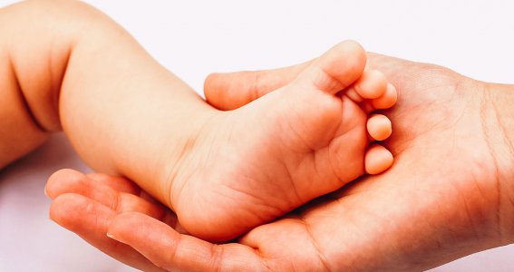 Mutter hält den Fuß ihres Babys 