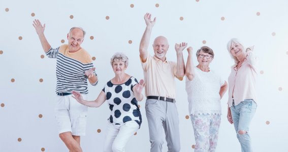 Eine fröhliche Gruppe von Senioren posiert tanzend
