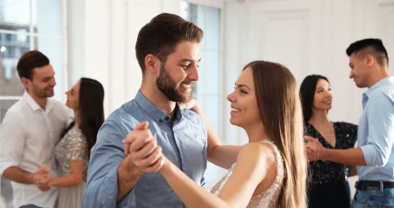 Drei junge Paare tanzen in einem hellen Raum