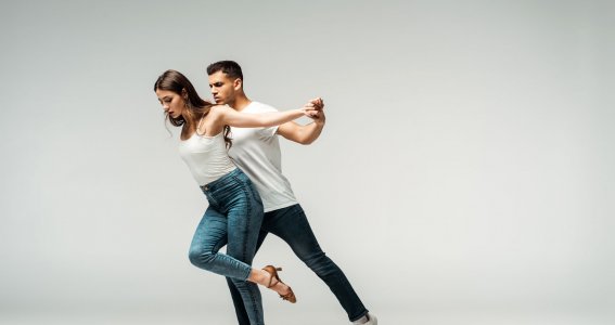 Ein Paar in blauen Jeans und weißen T-Shirts tanzt 
