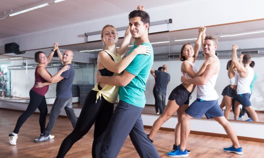 Drei Paare in Sportkleidung stehen in Tanzposition