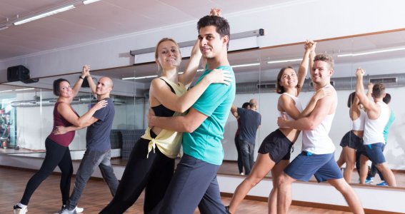 Drei Paare in Sportkleidung stehen in Tanzposition