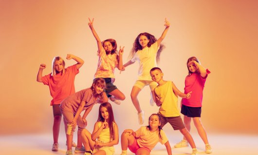 Eine Gruppe von Kindern posiert vor gelbem Hintergrund