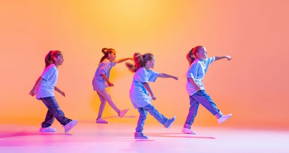 Vier Mädchen tanzen synchron in die gleiche Richtung 