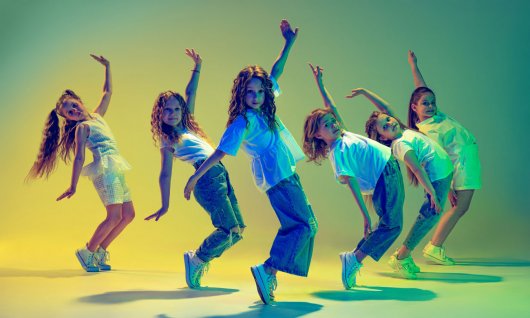 Eine tanzende Gruppe von Mädchen springt und posiert im Einklang