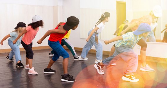 Kinder tanzen Hip Hop in einem Raum mit Spiegelwand