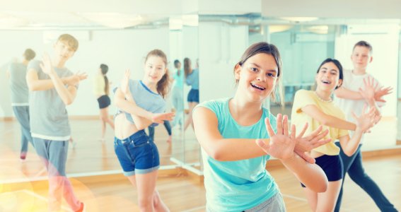 Fünf Jugendliche tanzen in einem Tanzstudio Hip Hop