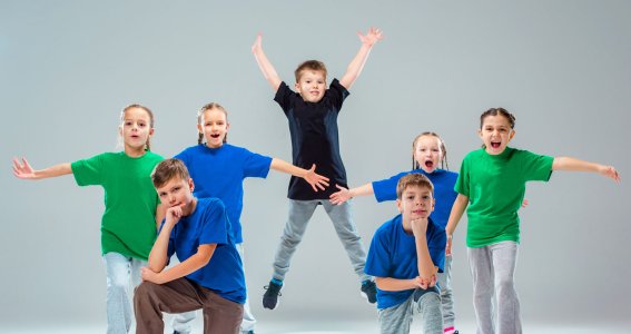 Eine Tanzgruppe posiert in Formation mit blauen und grünen Tshirts
