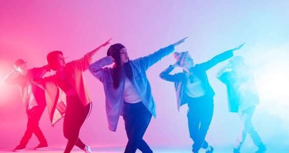 Jugendliche posieren in Hip Hop Formation in blauem und pinken Licht
