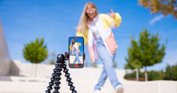 Ein Mädchen nimmt ein Video von sich auf, wie sie auf der Straße in lockerer Kleidung tanzt