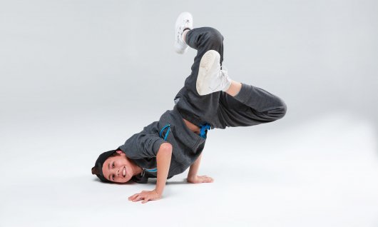 Ein Junge posiert in Breakdance Position am Boden