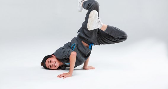 Ein Junge posiert in Breakdance Position am Boden