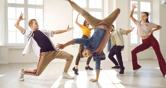 Einer Gruppe Breakdancer und ein junger Mann im Handstand in der Mitte