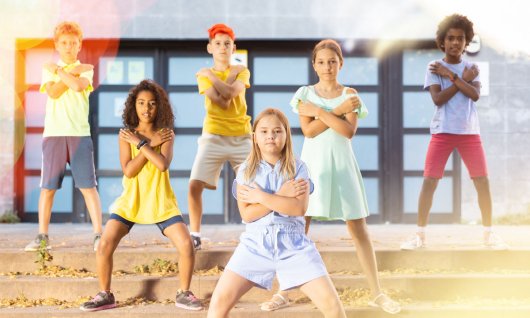 Kinder posieren in Tanzformation auf Stufen